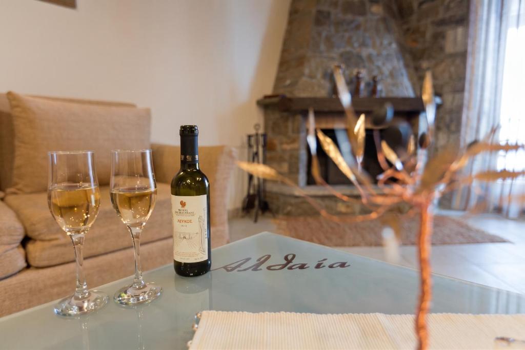 a bottle of wine and two glasses on a table at Althaia in Ano Chora