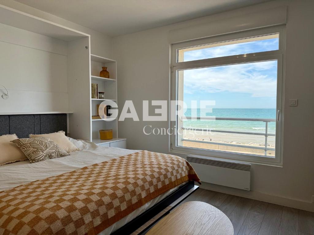 a bedroom with a window with a view of the beach at GC - Au Large - Front de Mer in Wissant