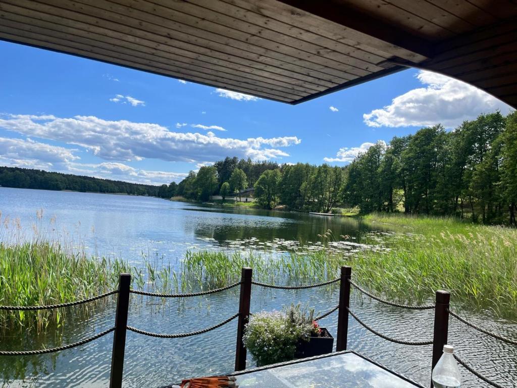 a view of a lake from a porch at Houseboat Przystań Spokoju in Ślesin