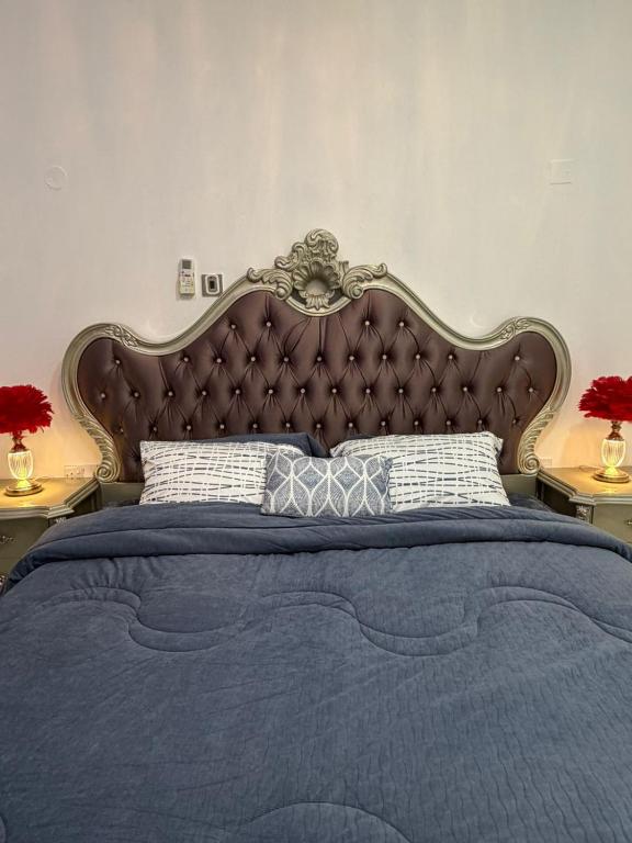ein Schlafzimmer mit einem großen Bett und einer blauen Decke in der Unterkunft Naforah in al-Ain