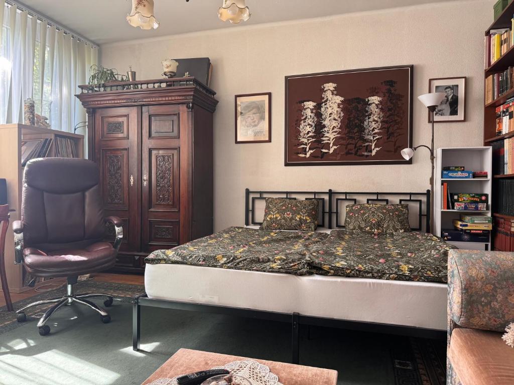 a bedroom with a bed and a chair at Egry Rooms in Veszprém
