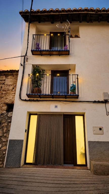 a white building with a balcony and a door at Casa Josefa Xiva Morella in Chiva de Morella