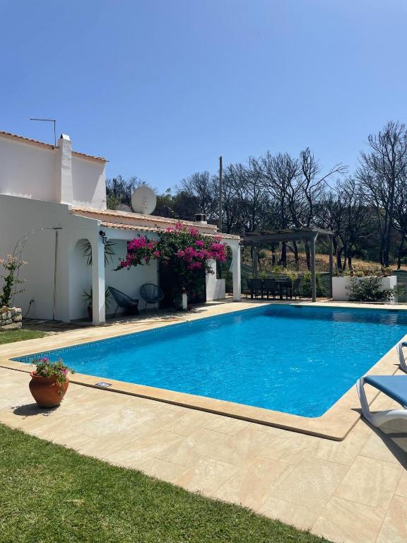a swimming pool in a yard next to a house at Vila Estrela in Vale do Lobo