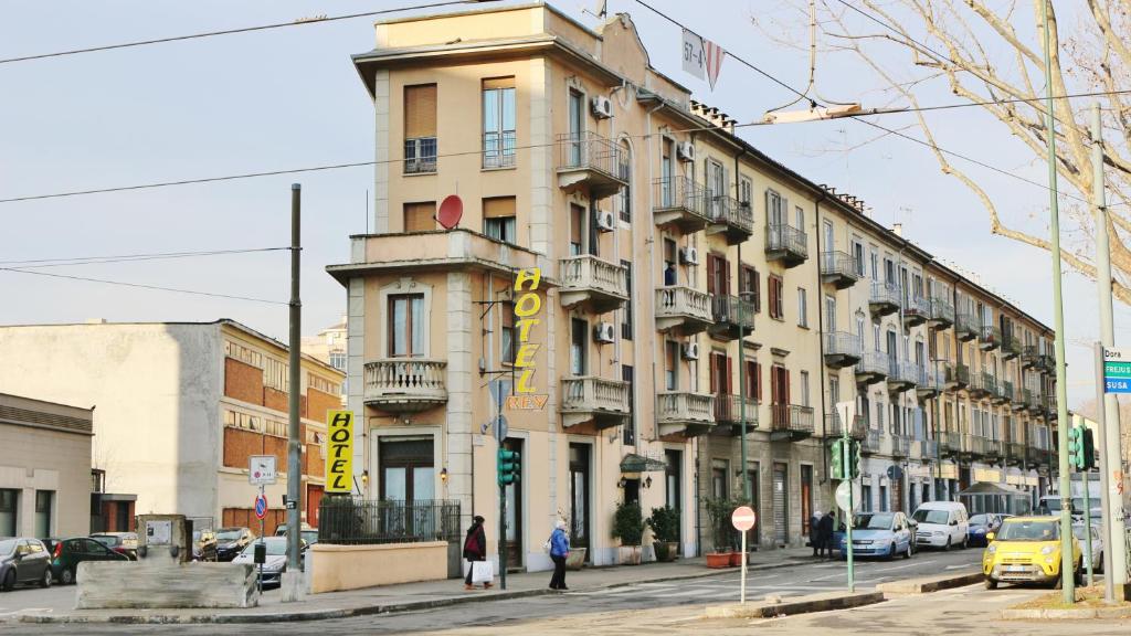 un edificio en una calle de la ciudad con gente parada frente a él en Hotel Rey, en Turín