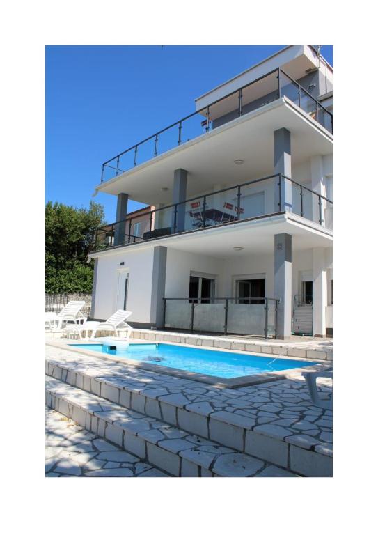 a house with a swimming pool in front of it at Villa Noah Apartement 2 in Novi Vinodolski