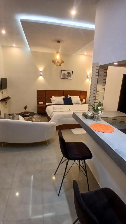 a large bedroom with a bed and a tub and a couch at PaoLia Meublé 3 in Cotonou