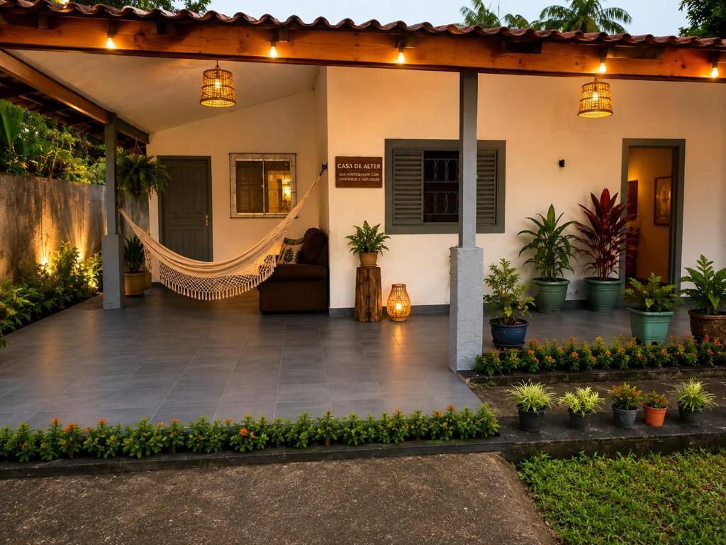 a patio with a hammock in front of a house at Casa de Alter - Hospedaria e Experiências in Alter do Chao