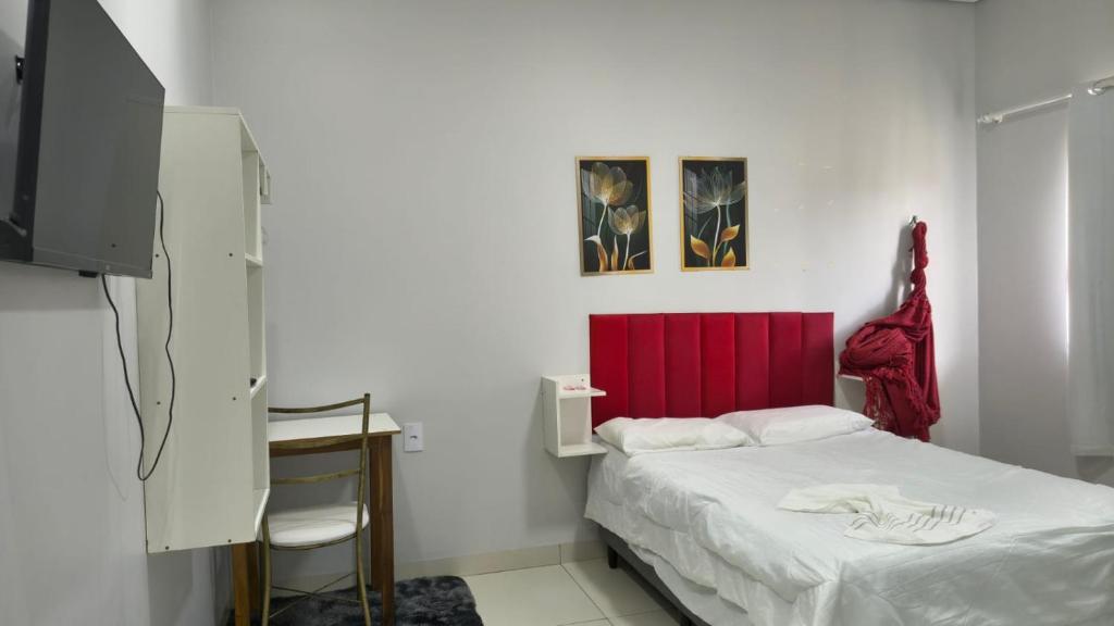a bedroom with a bed and a red headboard at Hotel Lara - Simolândia in Alvorada do Norte 
