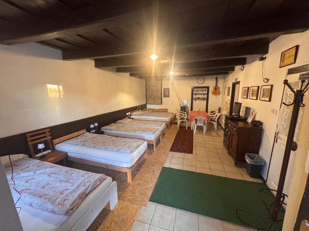 a room with four beds and a table and chairs at Görbeút Vendégház in Vigántpetend