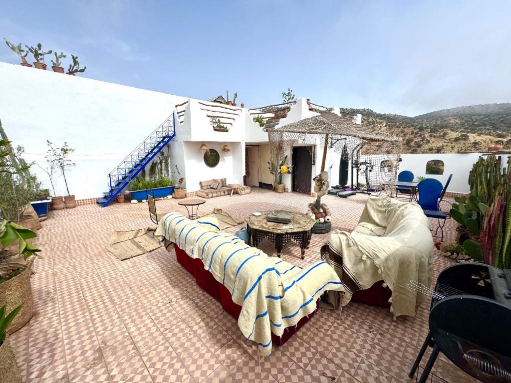 a patio with couches and a table and a building at Farissi's Zawya Surf House in Aourir