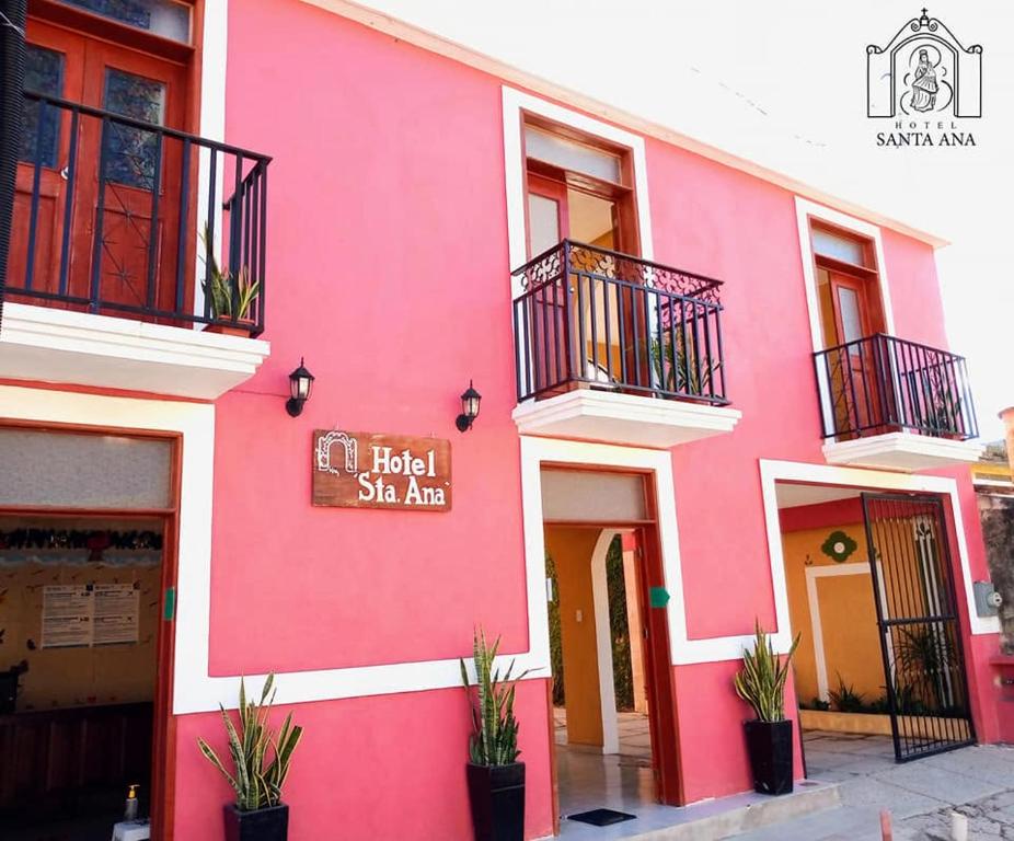 a pink building with plants in front of it at Hotel Santa Ana in Valladolid