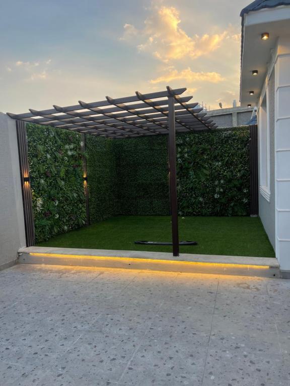 a wooden pergola on the side of a house at شالية السلطان 1 in Khamis Mushayt