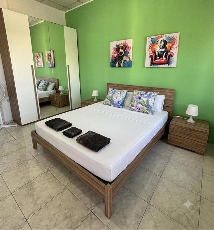 a large bed in a room with a green wall at Victoria Centre 2BR - Opposite Bus Terminal in Victoria