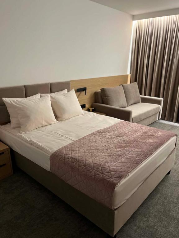 a hotel room with a bed and a couch at No 11 Residence in Krynica Morska