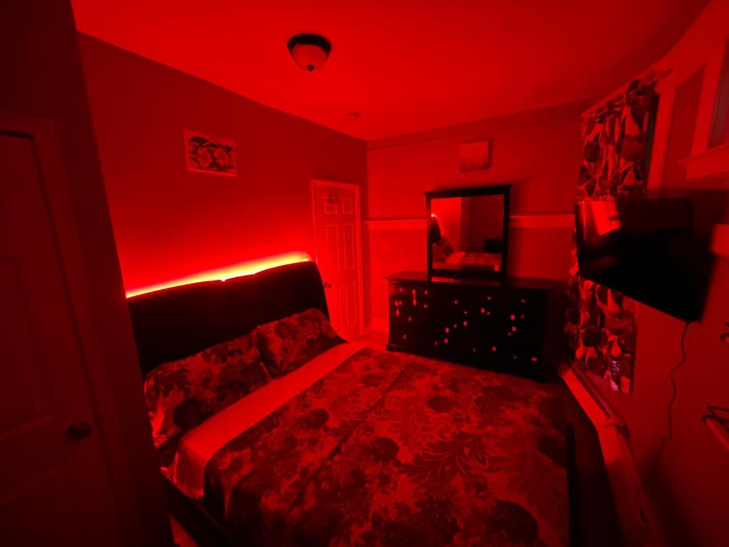 a red bedroom with a bed with a red light at Stylish Red LED Bedroom in Irvington