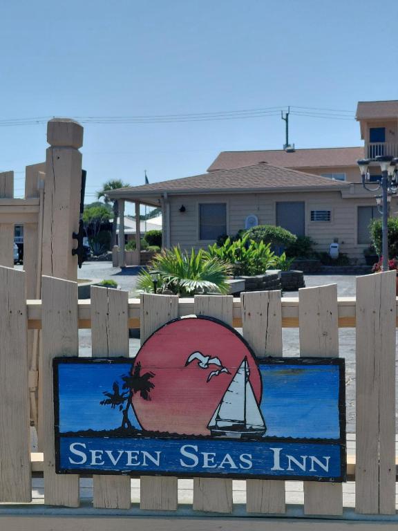 a sign for the seven seas inn on a wooden fence at Seven Seas in Kure Beach