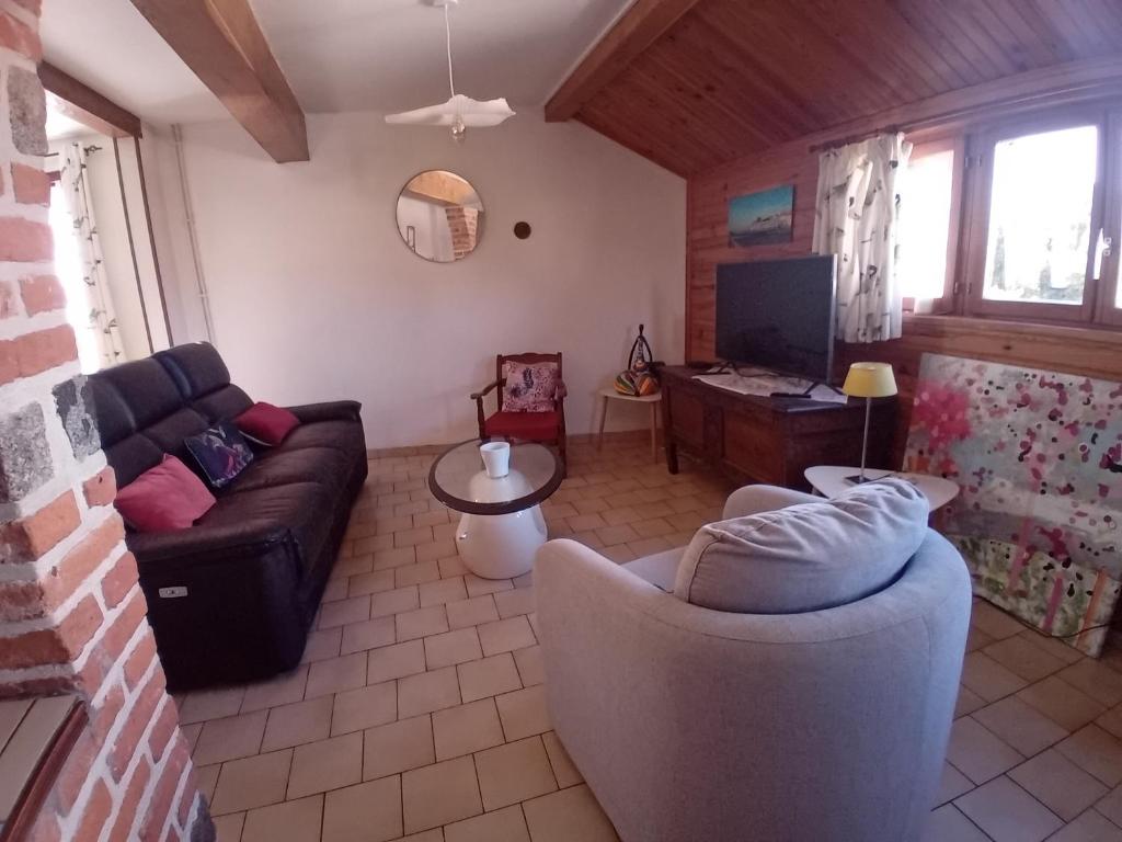 a living room with a couch and a tv at oiseau bleu in Dieppe