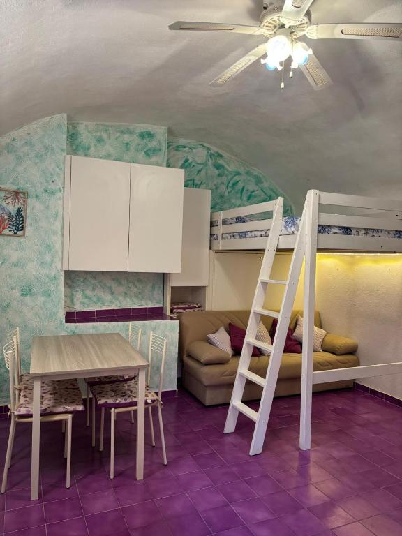 a room with a bunk bed and a table and a ladder at Il tuo rifugio all' Argentario in Porto Santo Stefano
