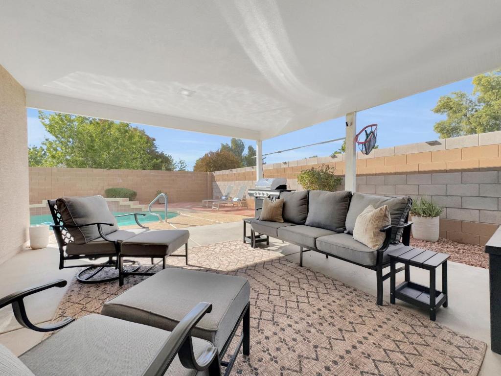 a patio with a couch and chairs and a pool at 153rd Surprise in Surprise