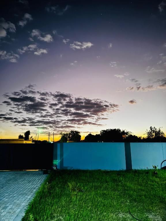 a view of the sunset over a fence and grass at P Daisy in Rundu