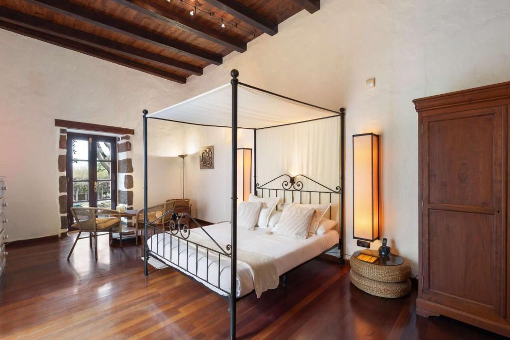 Un dormitorio con una cama con dosel en una habitación. en Villa Muller by Bayside - The Fountain of Silence, en Tías