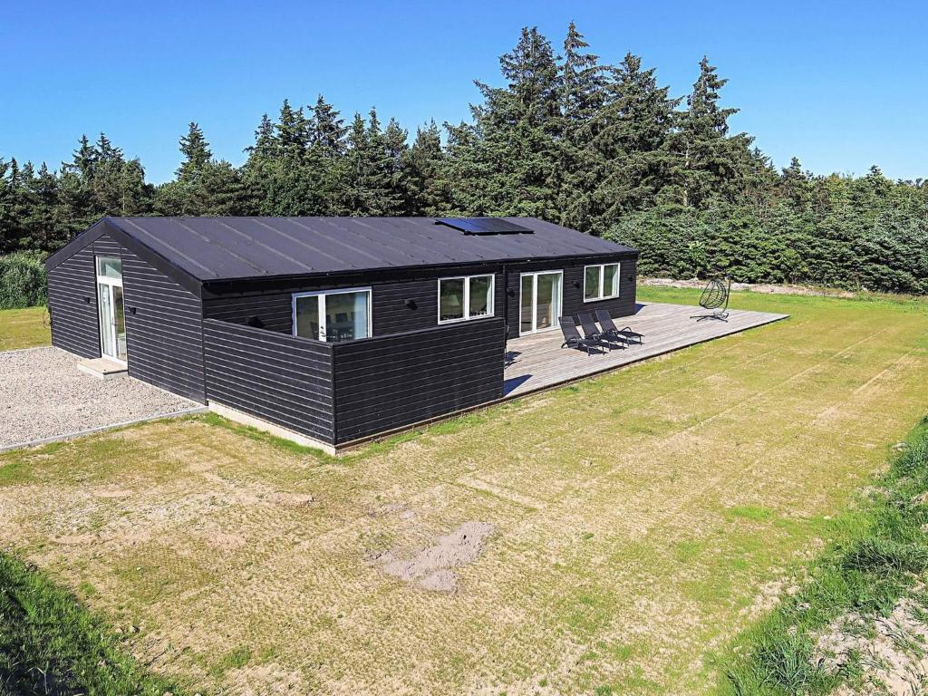 a black tiny house sitting on top of a yard at Saltum Beach Luxury & Wellness in Saltum