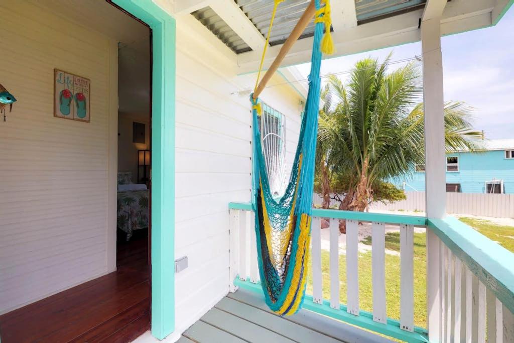 a porch with a hammock on a house at DV #2 at DV Cabanas -Gold Standard Certified in Caye Caulker