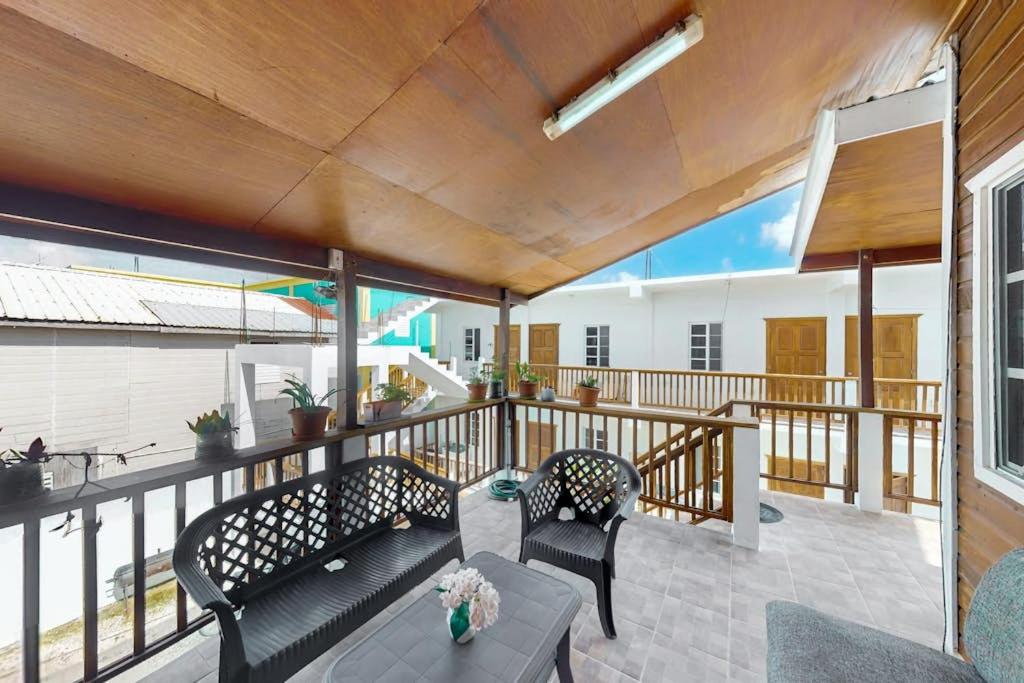 a patio with two chairs and a table on a balcony at Spartan Unit 11 in Caye Caulker