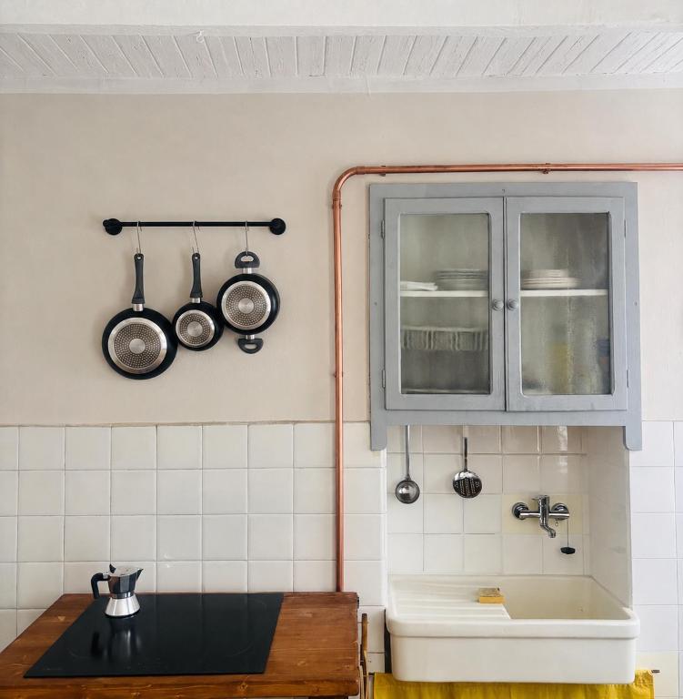 a kitchen with a sink and a window with utensils at Casa Giù Là in Quarna Sopra