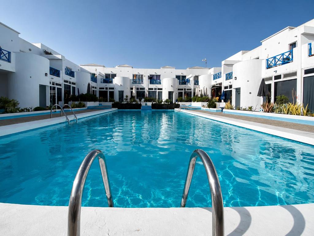 a swimming pool in front of a building at Vanessa Puerto del Carmen in Tías