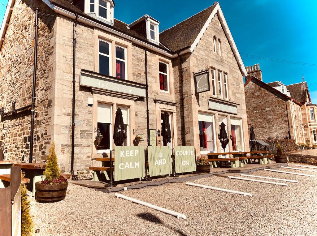 a building with akeep calm sign in front of it at The Courie Inn in Killin
