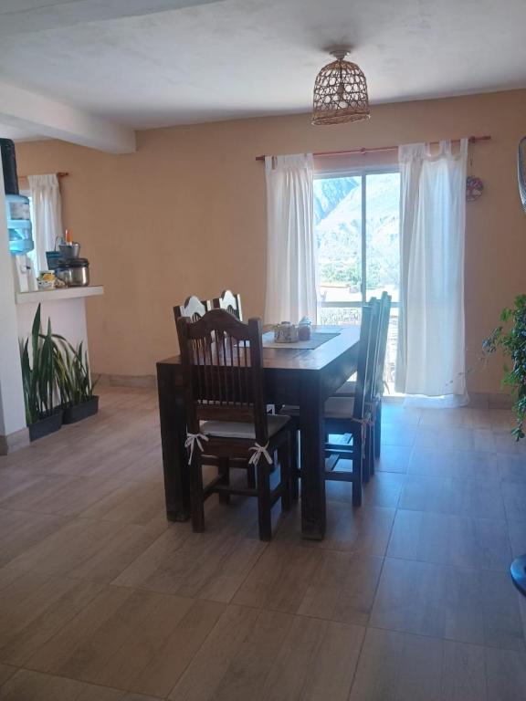 a dining room with a table and chairs and a window at Casa Las Pencas in Maimará