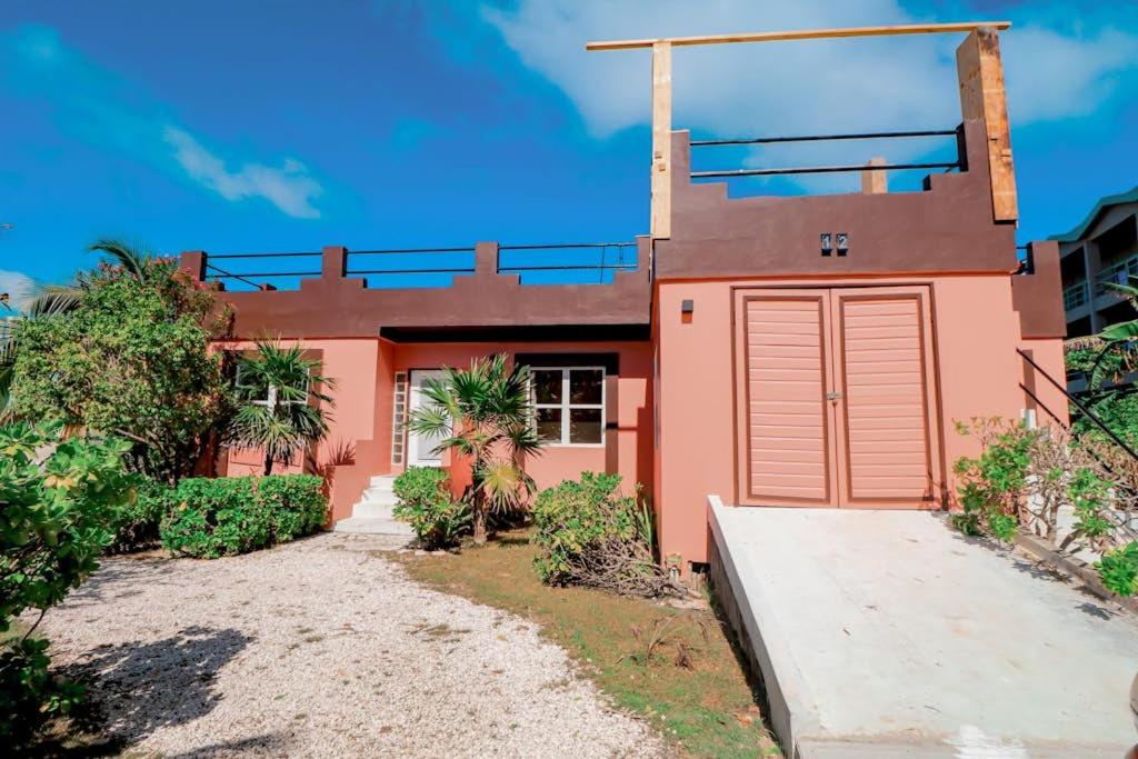 a pink house with a red garage at Villa 12 at Mara Laguna - Gold Standard Certified in San Pedro