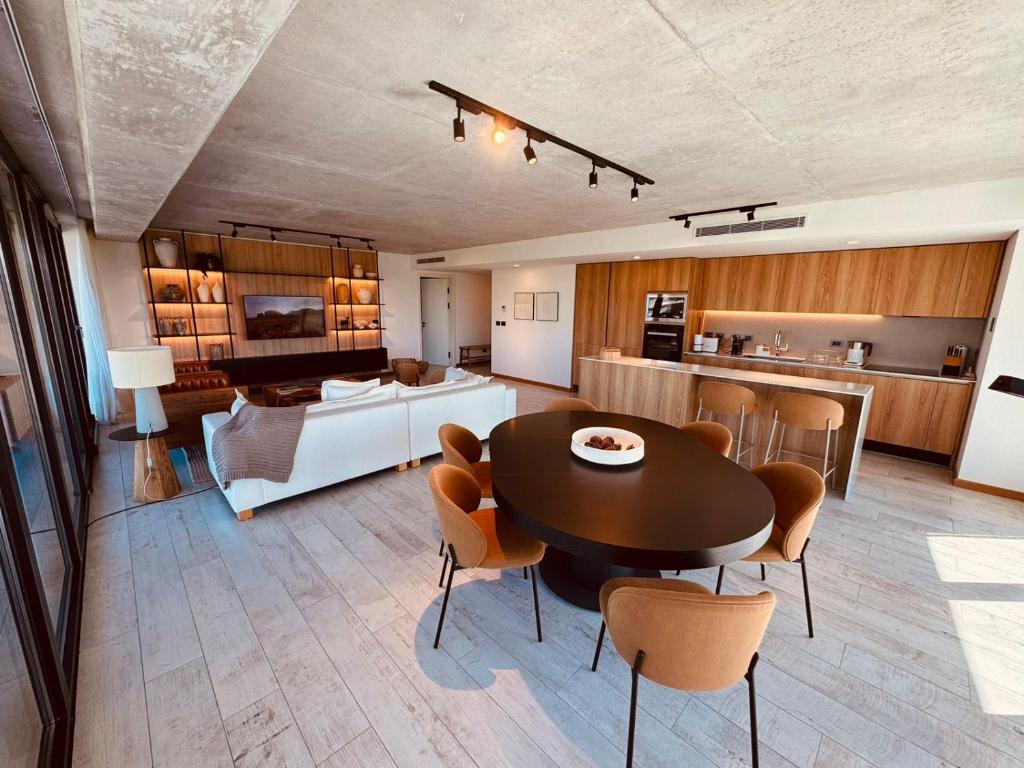a living room and kitchen with a table and chairs at Surfside - 3 Suítes - 4 Bathroom in Punta del Este
