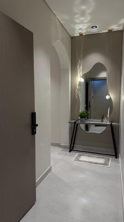 a hallway with a bathroom with a sink and a mirror at Rose House 2 in Taif