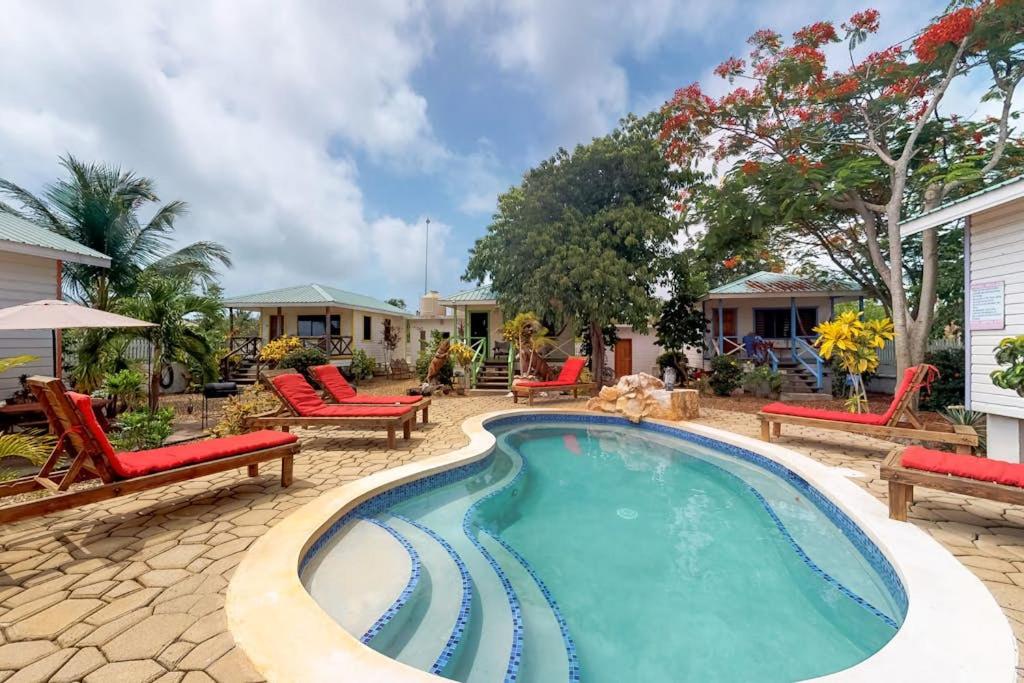 a swimming pool with red chairs and a patio at Latitude Adjustment Gold Standard Certified in Hopkins
