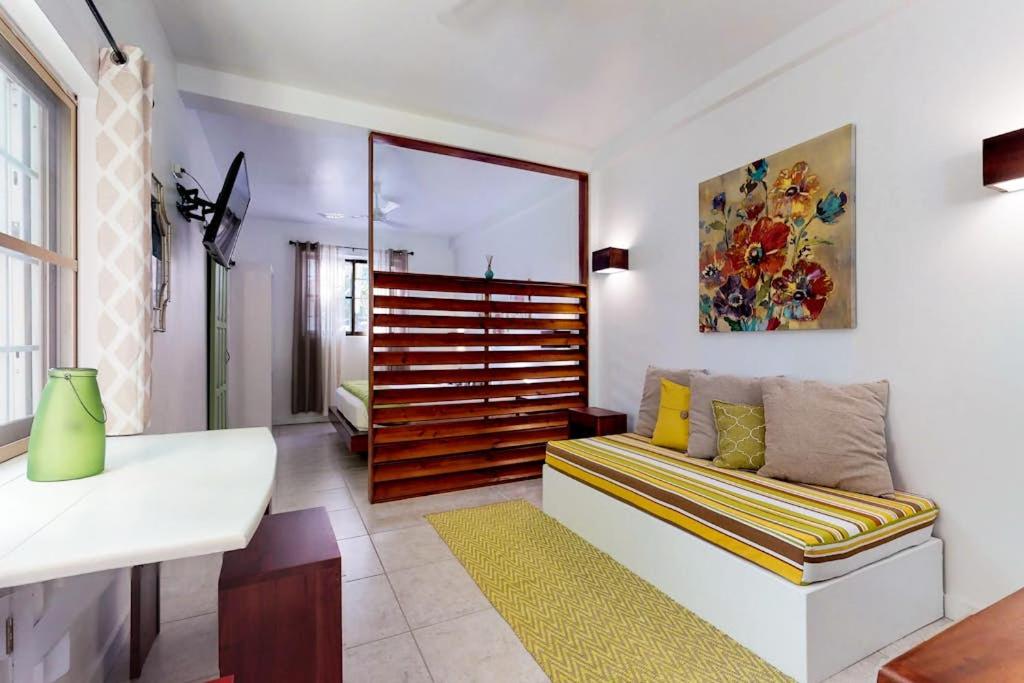 a living room with a couch and a mirror at Rainforest Suite at Casa DV Suites -Gold Standard Certified in Caye Caulker