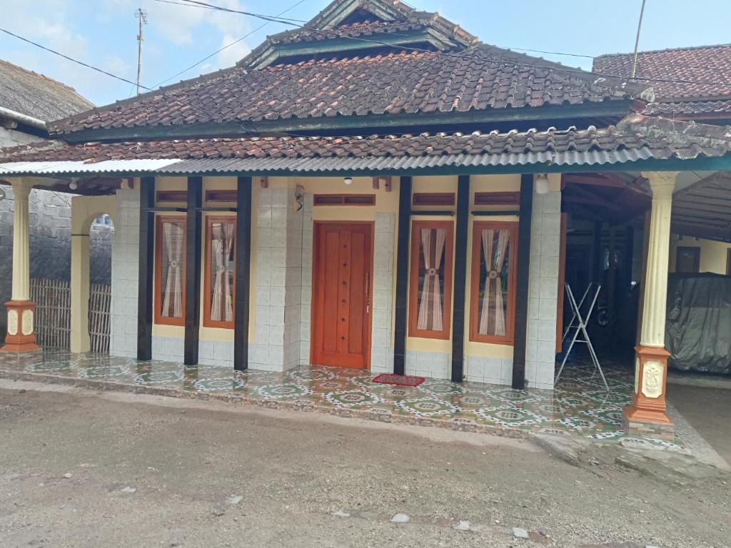 a building with a red door on a street at Jupe Homestay batukaras in Batukaras