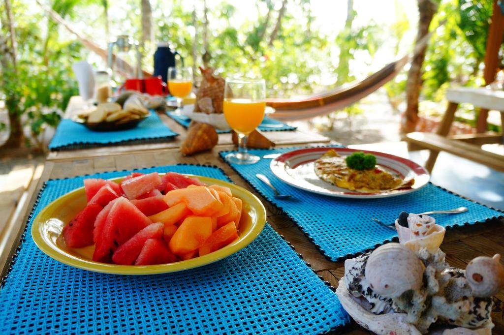 einen Tisch mit Teller mit Lebensmitteln und Obst darauf in der Unterkunft Cebaco Sunrise Lodge in Isla Cebaco 
