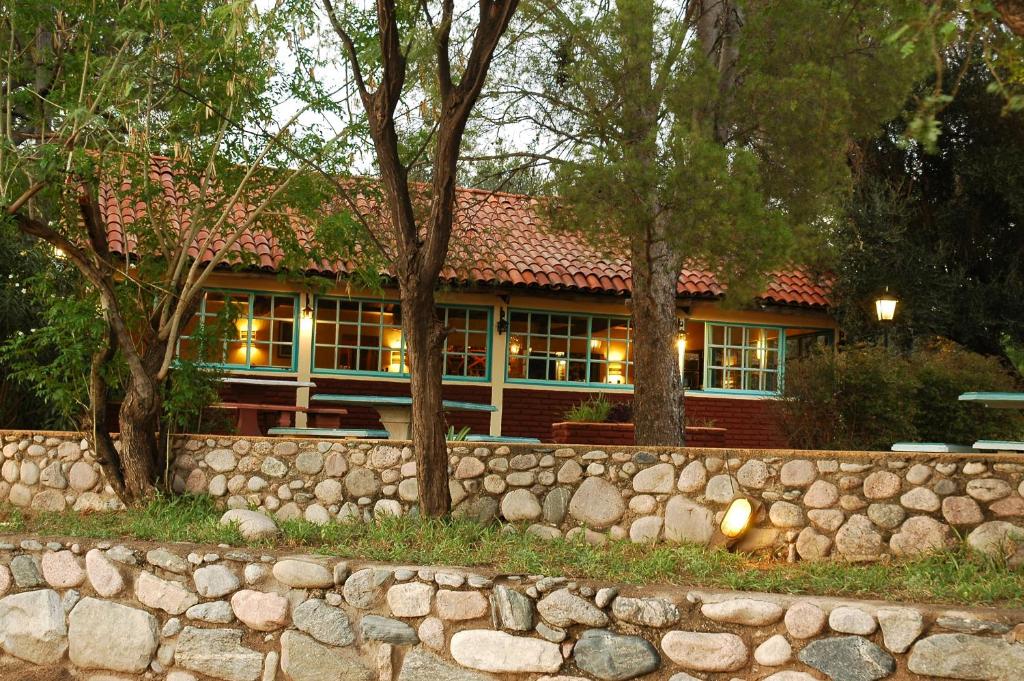 una casa con una pared de piedra delante de ella en Cabañas Los Quijotes en San Marcos Sierras