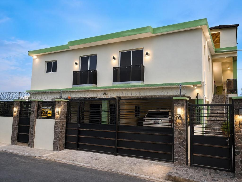 a white building with a black garage door at HERGOZ Apartamentos in Cayetano Germosén