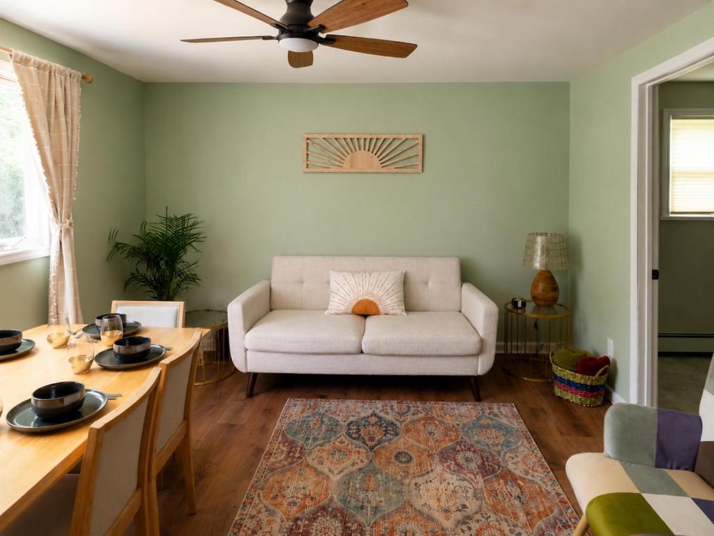 a living room with a white couch and a table at Grateful Manor-Close to Downtown- Sauna in Livingston Manor