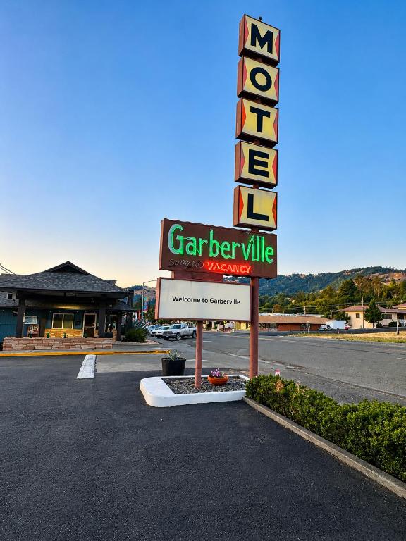 a sign for a car dealership in a parking lot at Motel Garberville in Garberville