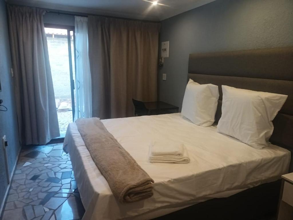 a bedroom with a bed with two towels on it at Lifeshed in Johannesburg