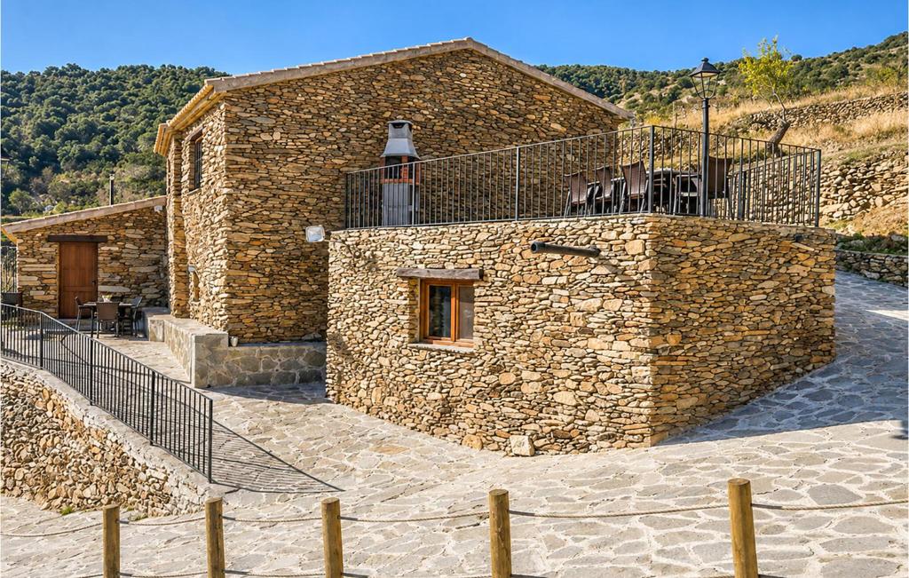 a stone building with a balcony on top of it at Yerbaluisa in Laroya