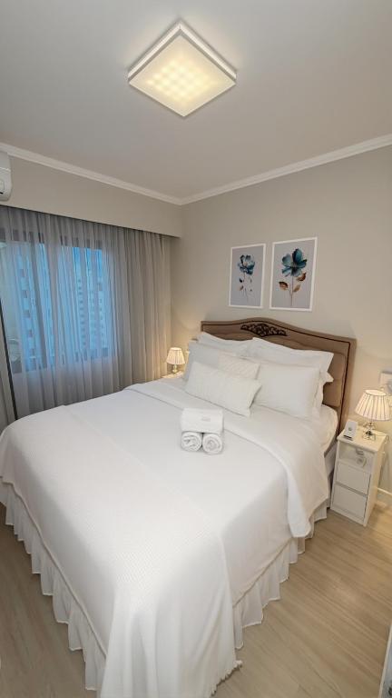 a bedroom with a large white bed with white pillows at Ibirapuera Privilege - Suíte Deluxe Moema in São Paulo