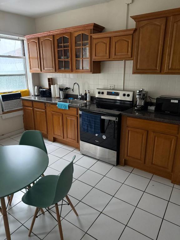 a kitchen with wooden cabinets and a stove top oven at Madison - Shared apartment in New York