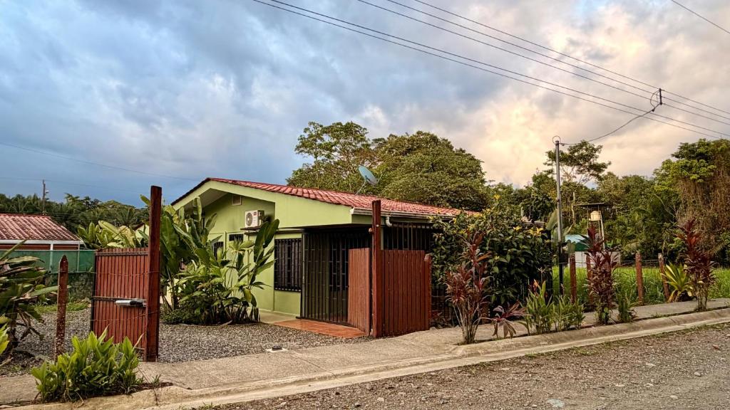 a small house with a fence in front of it at Casa Pentagonia in Puerto Jiménez