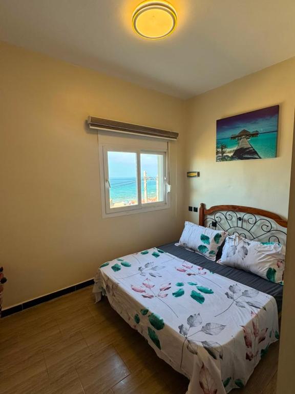 a bedroom with a bed with a view of the ocean at اقامة حسن الجوار in Oran