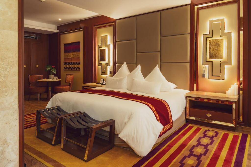 a hotel room with a large bed and a table at Colpapampa Lodge in Colcapampa